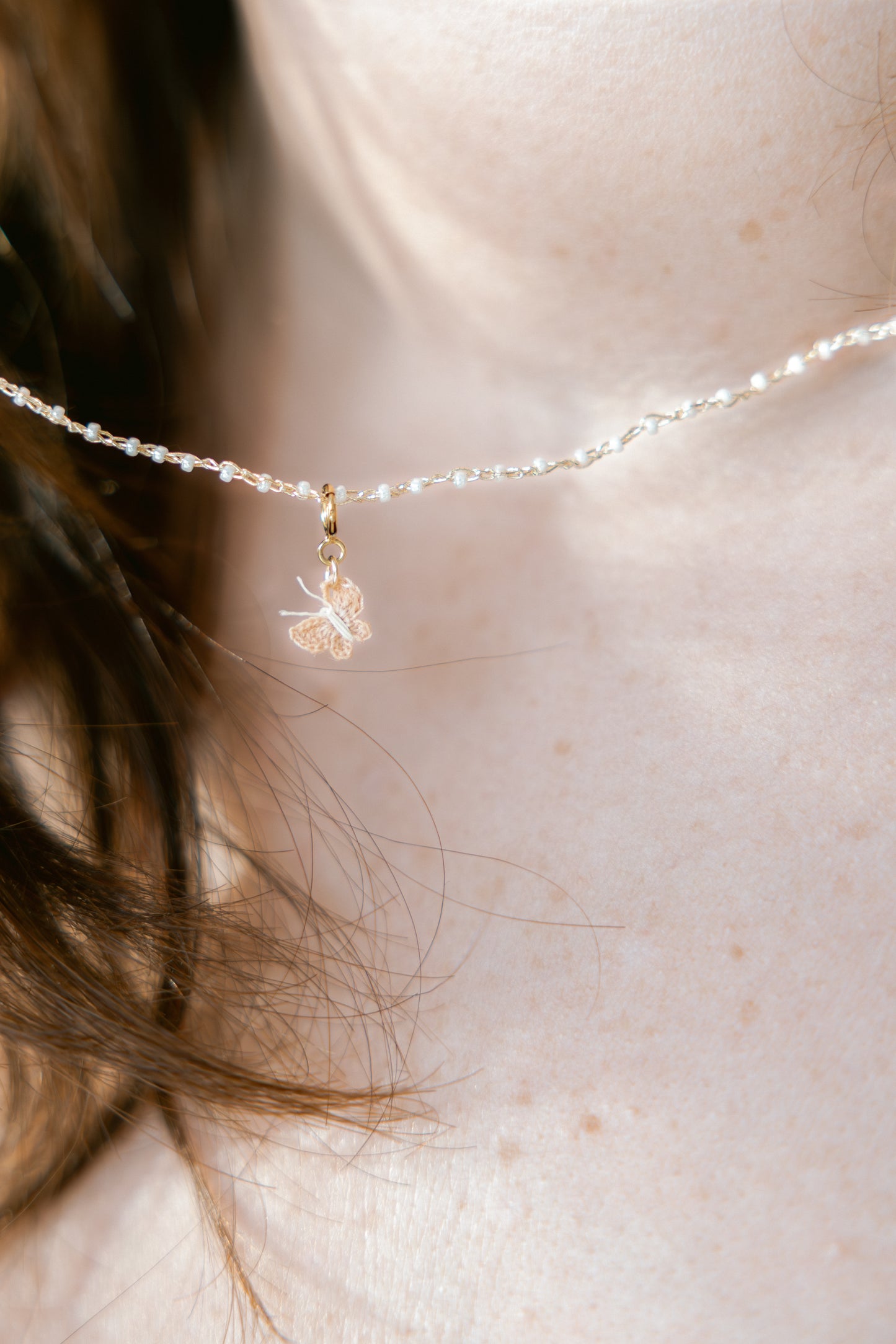 Yara ketting op model, gehaakte vlinder en ketting, witte parelglanskraaltjes, gouddraad, vlindertje 1 cm