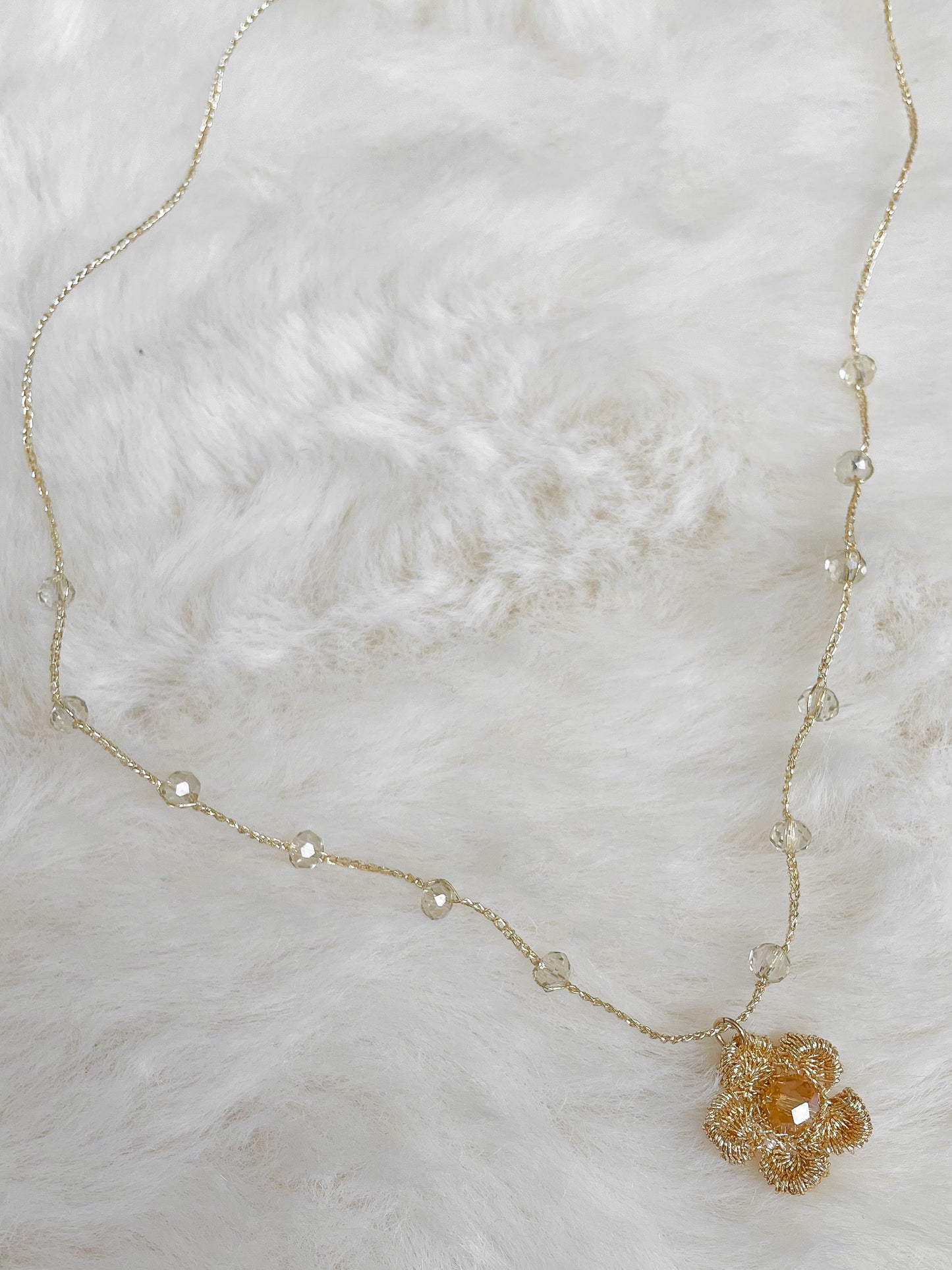 Gehaakte ketting bloembedel met kernkraal facet glaskraal in warme tint.