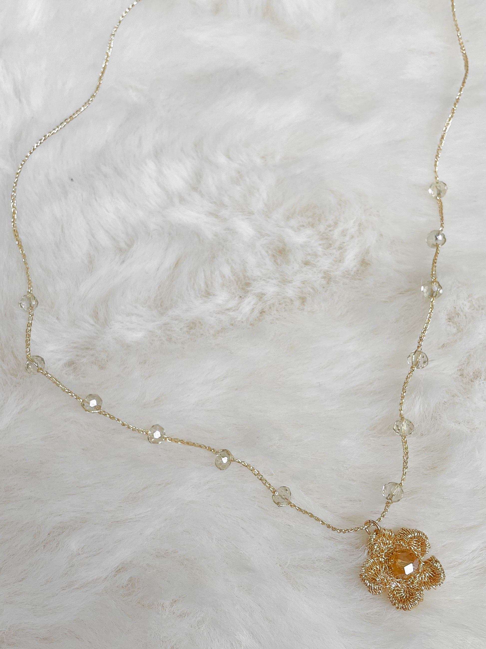 Gehaakte ketting bloembedel met kernkraal facet glaskraal in warme tint.  