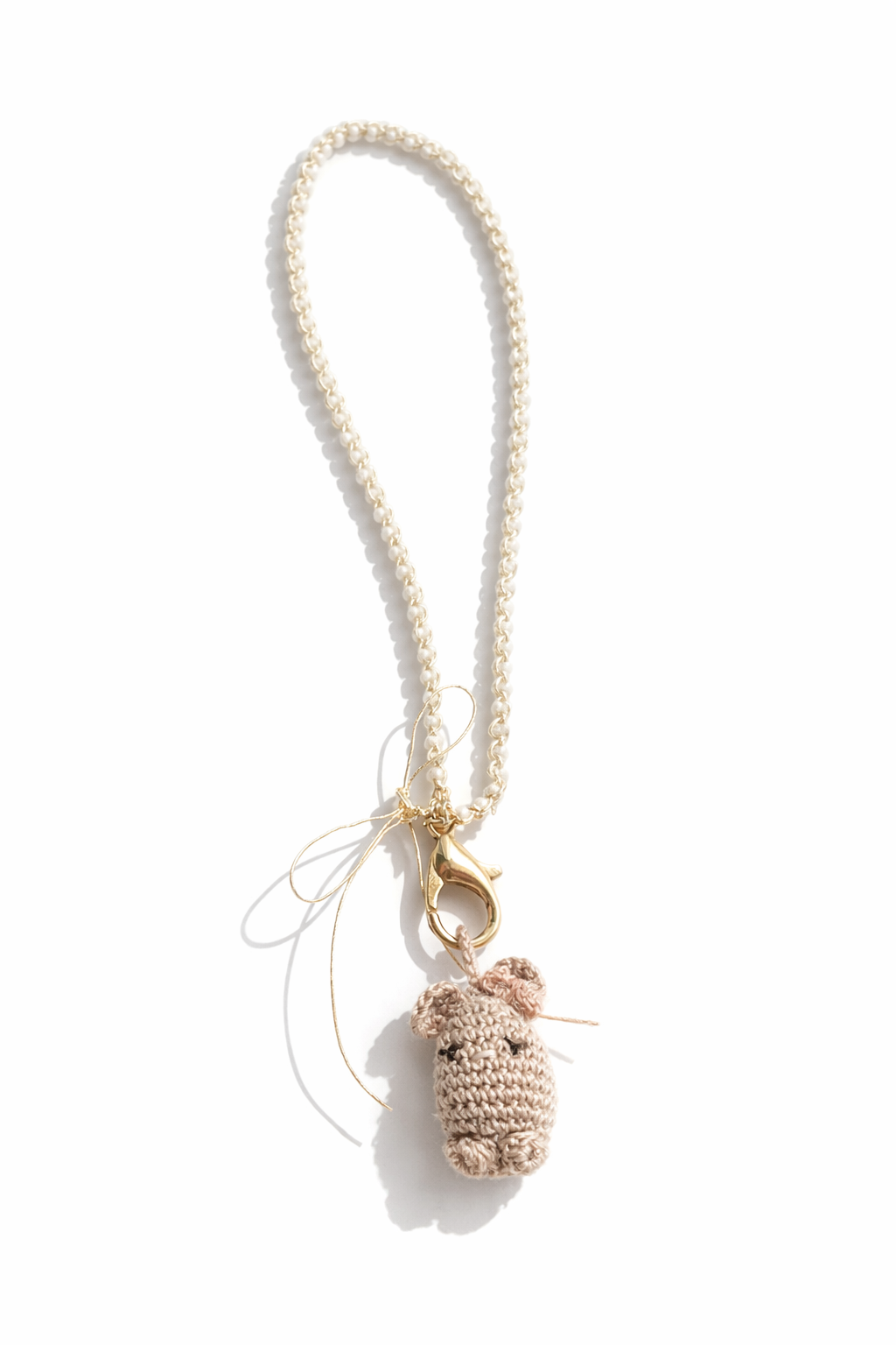 Ginny micro gehaakte bag charm, product foto wit achtergrond, hamster; amigurumi, taupe met strikje. 